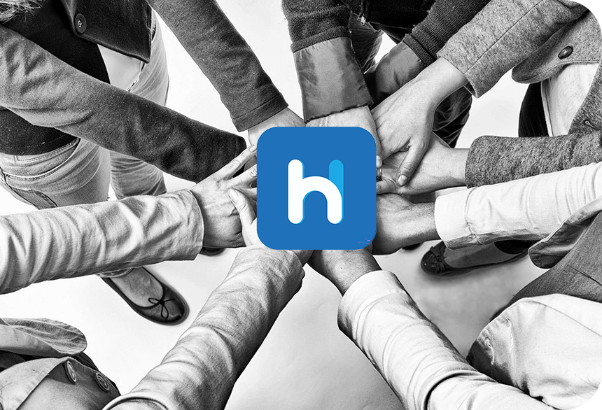 A group of people holding hands in a circle with the word h.